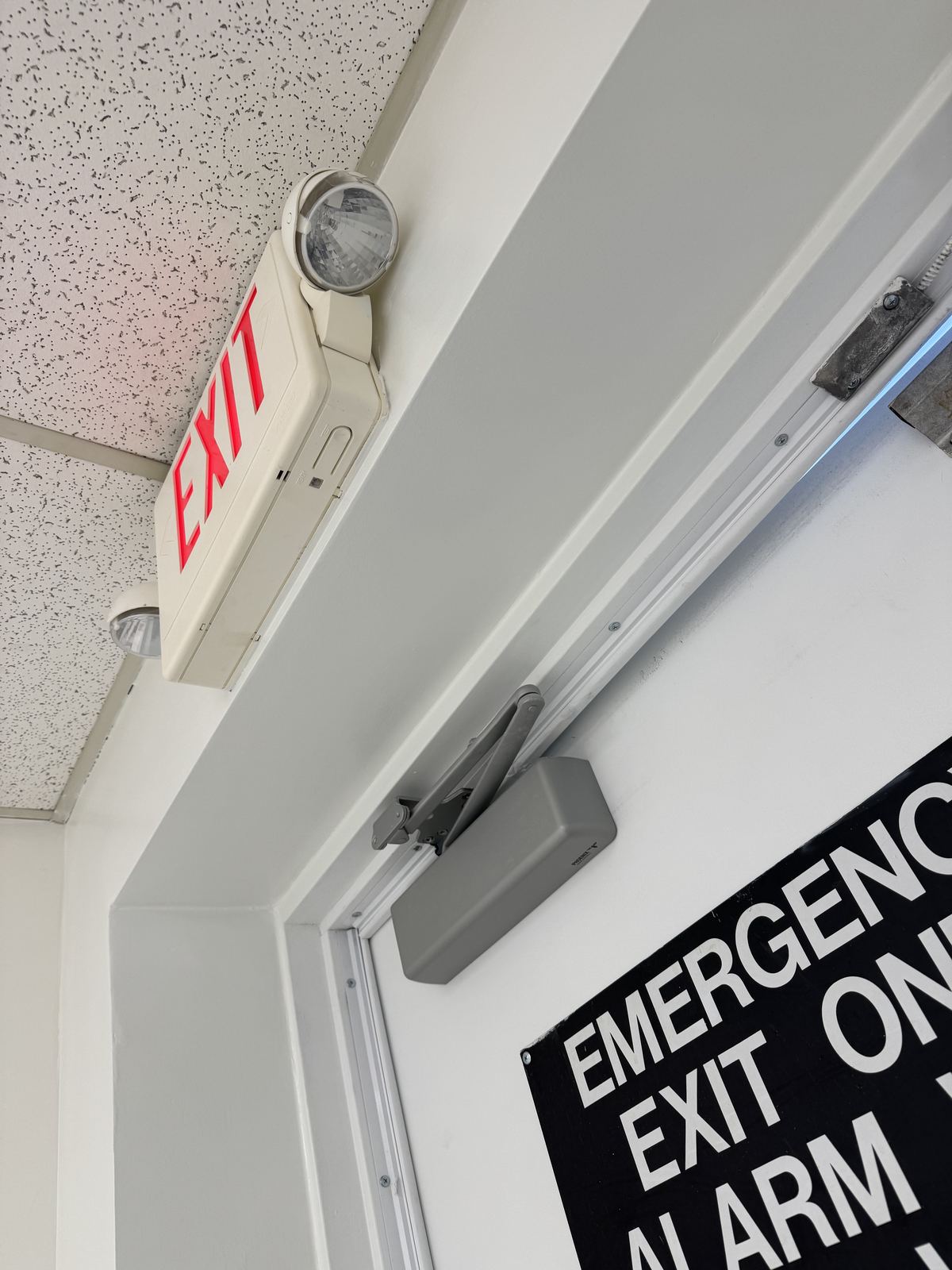 Finished emergency exit doorway with clean paint and exit lighting
