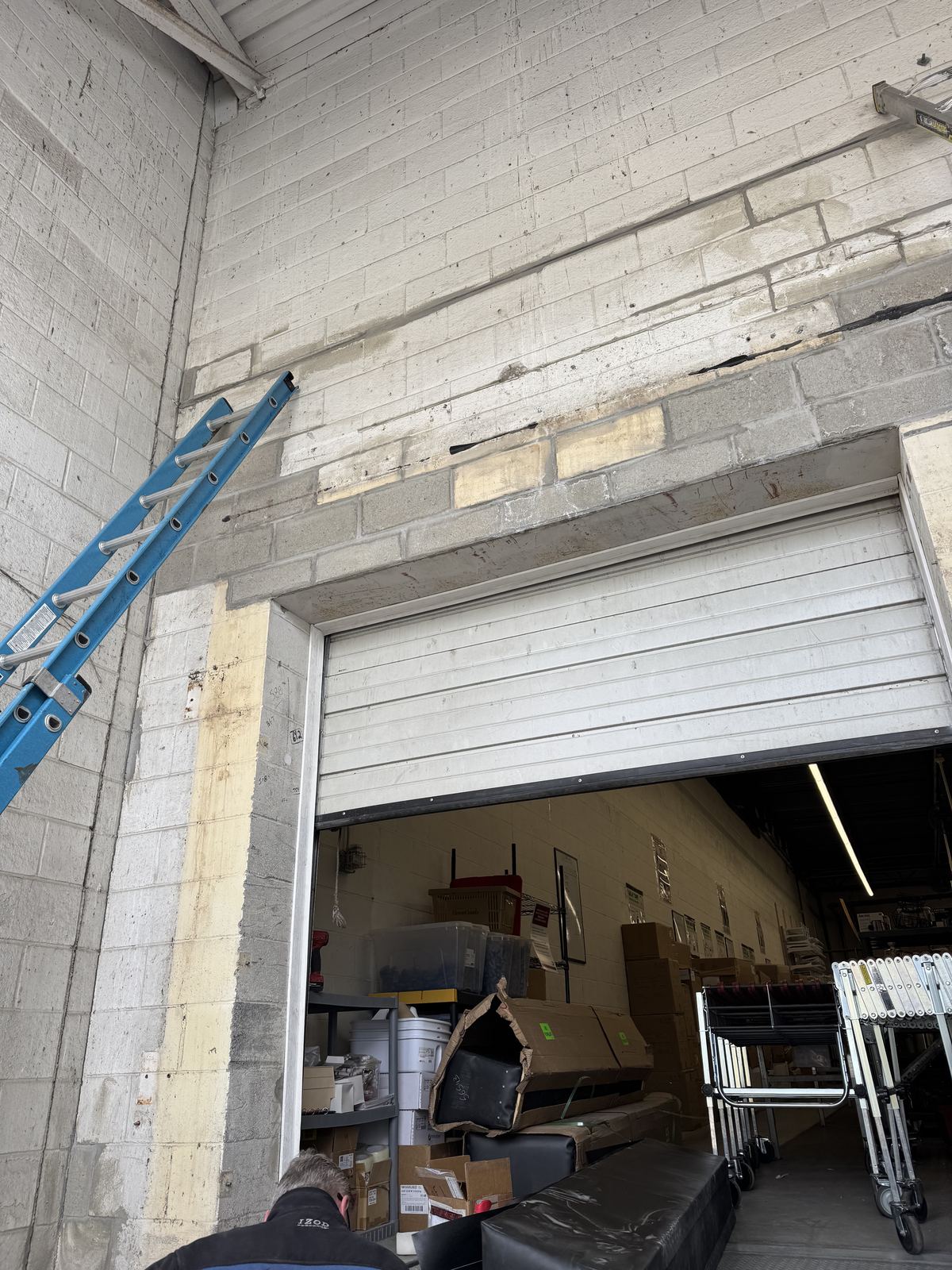 Loading dock doorway with damaged masonry above the overhead door