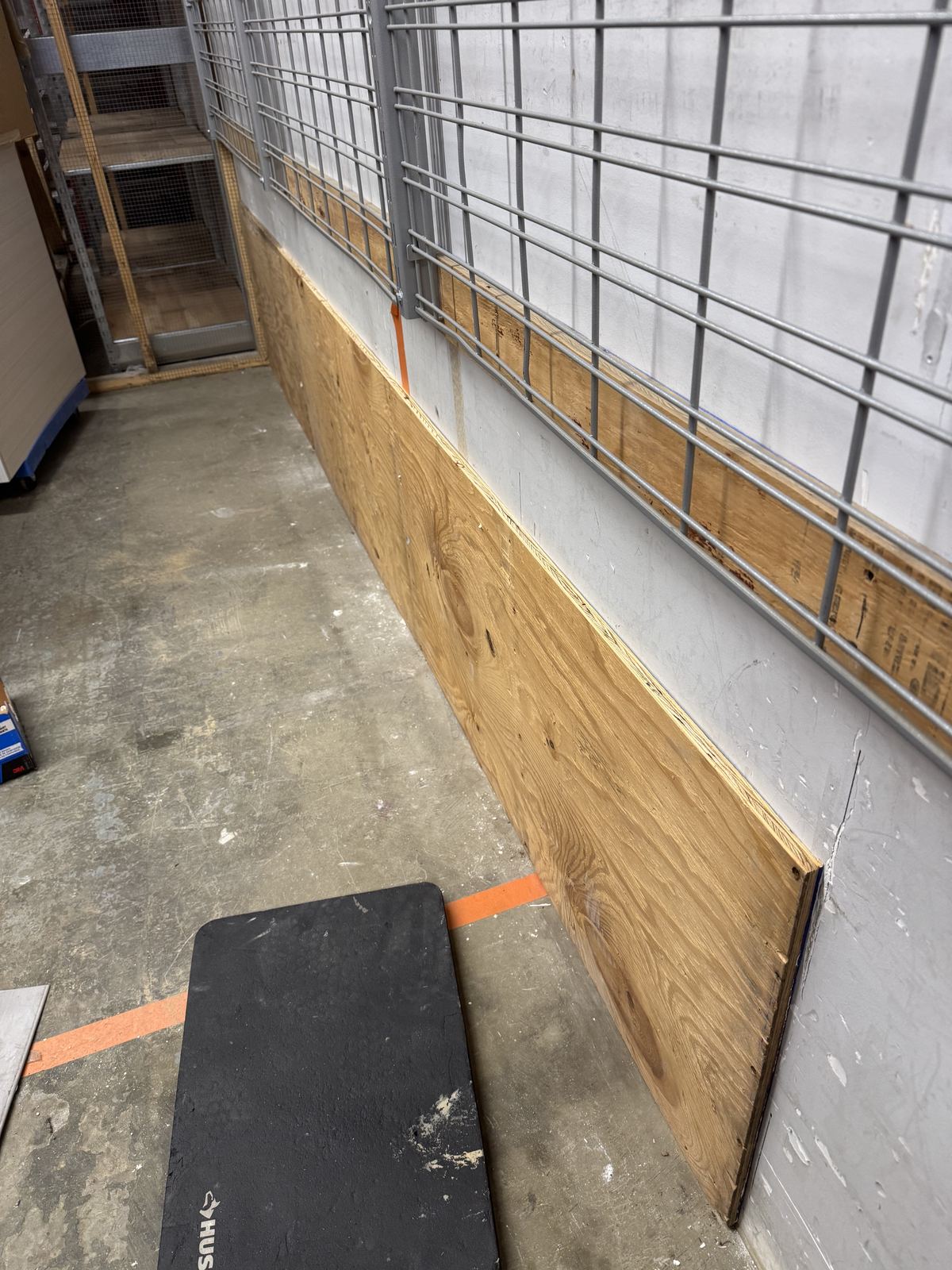 Stockroom aisle with new plywood wall protection installed