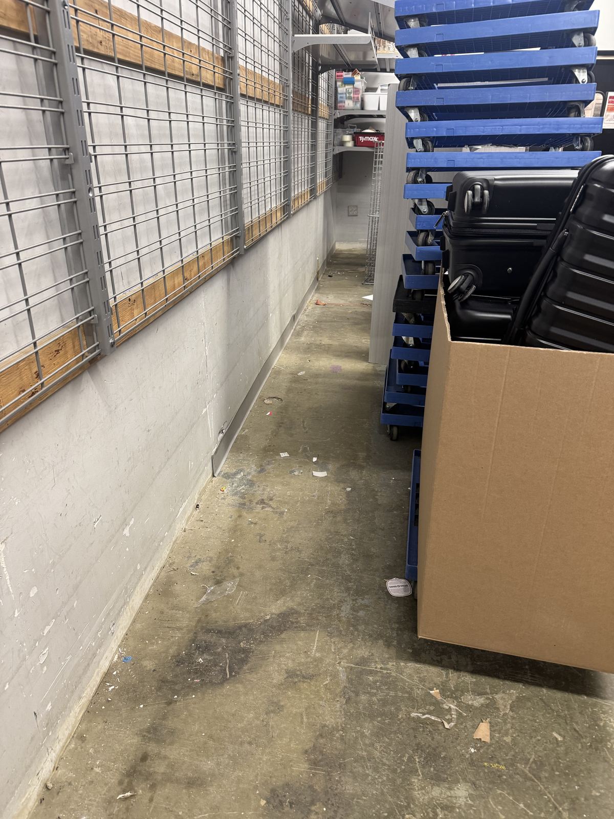 Stockroom aisle with bare damaged wall along storage racks